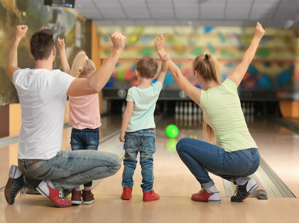 A family bowling, one of the best rainy day activities on Cape Cod.