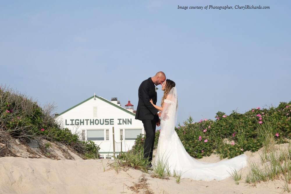A couple taking pictures in front of Lighthouse Inn, one of the top Cape Cod venues for micro weddings.