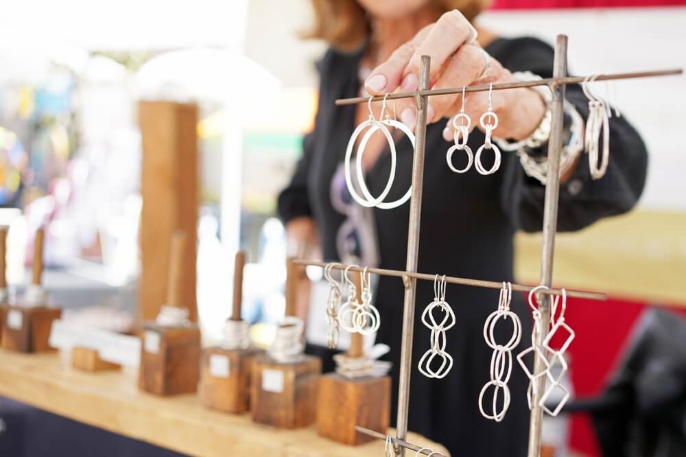 A vendor setting up her jewelry at Brewster in Bloom.