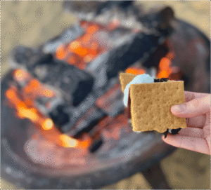 A person making a s'more on a Cape Cod summer vacation.