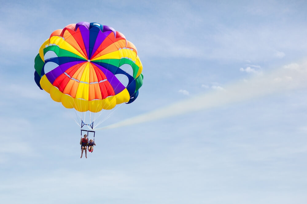 People parasailing on a Cape Cod summer vacation.